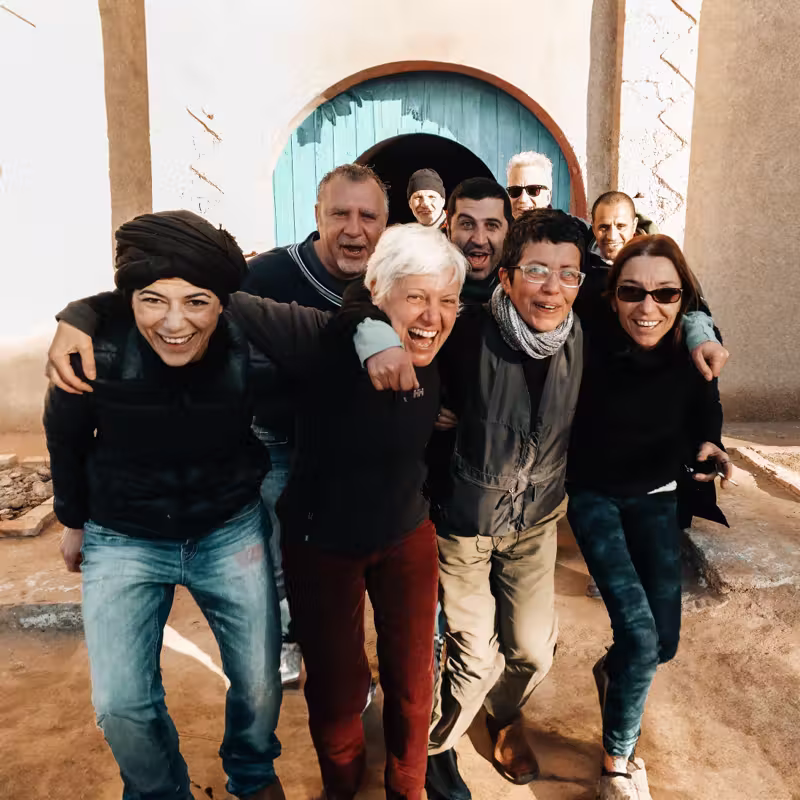 Amici abbracciati davanti alla porta blu di Dar Haroun